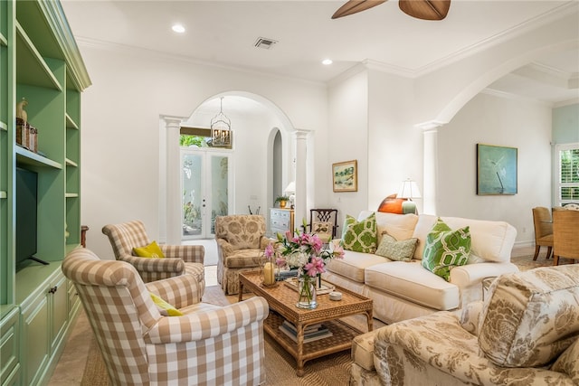 living room featuring crown molding, ceiling fan, and ornate columns