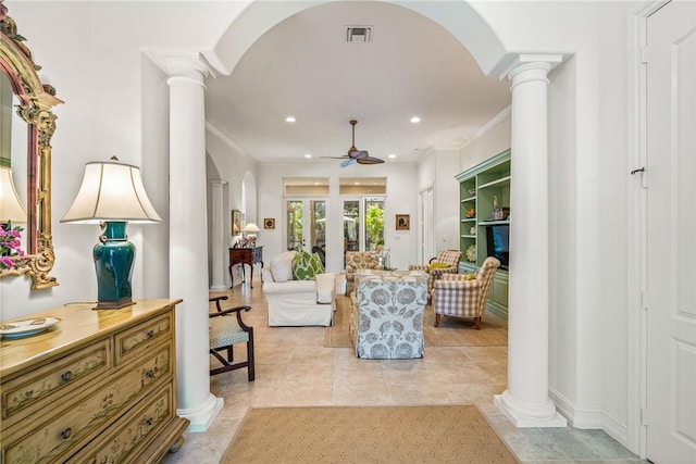 sitting room featuring ceiling fan, ornamental molding, light tile patterned floors, and ornate columns