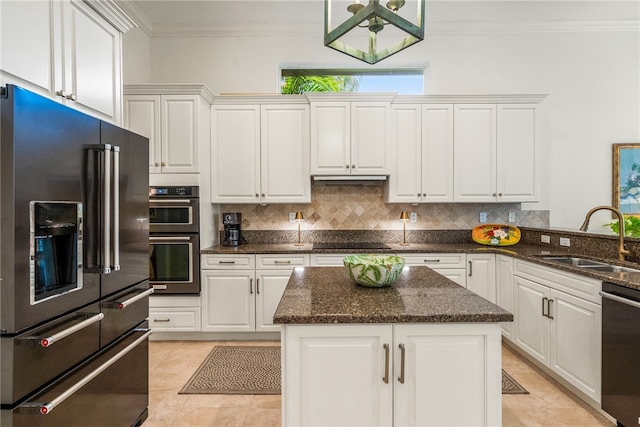 kitchen with dark stone counters, a center island, sink, white cabinetry, and appliances with stainless steel finishes