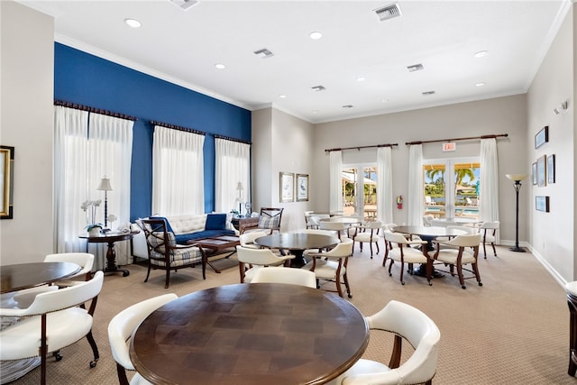 carpeted living room featuring crown molding and a high ceiling