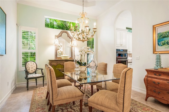 tiled dining room featuring a notable chandelier and ornamental molding