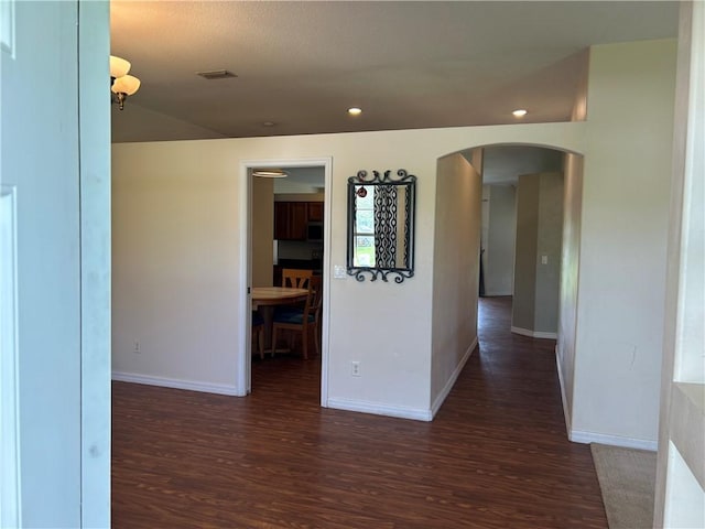 8475 101st Ct, Vero Beach, FL 32967 - hallway featuring arched walkways, wood finished floors, and recessed lighting