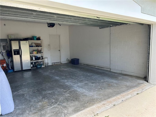 8475 101st Ct, Vero Beach, FL 32967 - garage featuring refrigerator with ice dispenser, a garage door opener, and concrete block wall