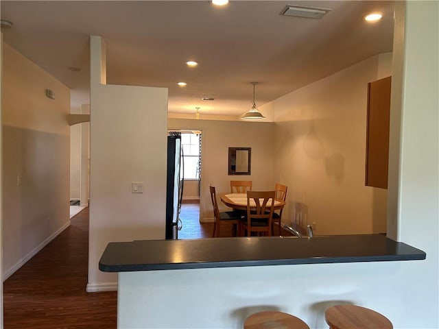 8475 101st Ct, Vero Beach, FL 32967 - kitchen featuring freestanding refrigerator, dark wood-type flooring, recessed lighting, dark countertops, and decorative light fixtures