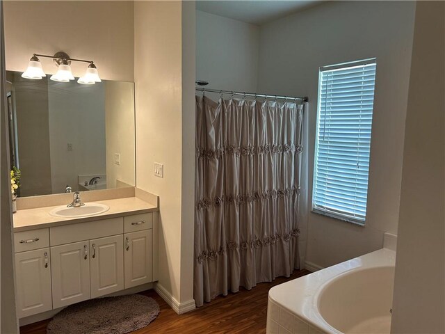 8475 101st Ct, Vero Beach, FL 32967 - bathroom with a bath, vanity, wood finished floors, and curtained shower