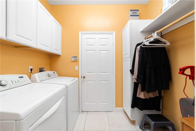 washroom featuring separate washer and dryer, light tile patterned floors, and cabinets