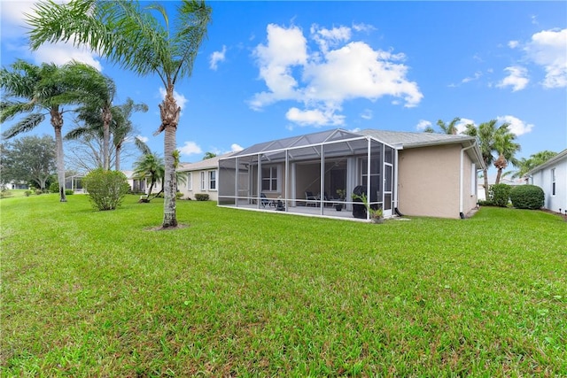 back of property with a yard and glass enclosure