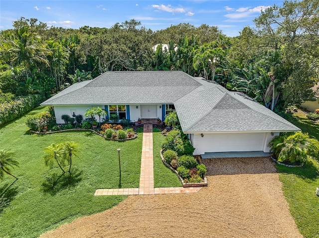 ranch-style house featuring a garage and a front lawn