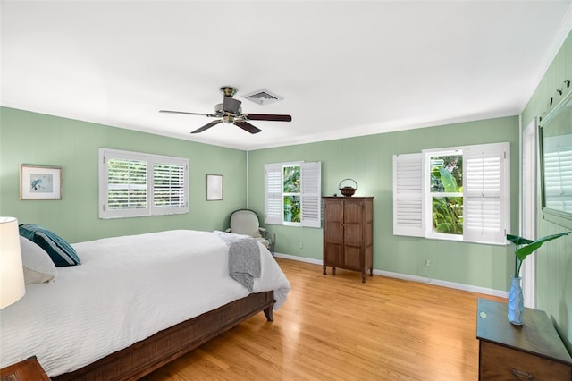 bedroom featuring ceiling fan, crown molding, and light hardwood / wood-style flooring