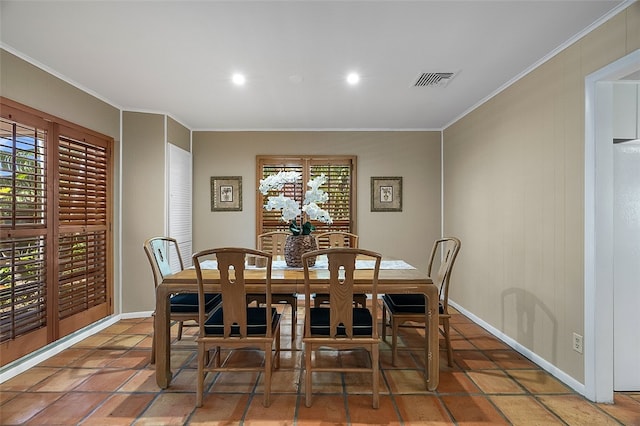 tiled dining room featuring crown molding