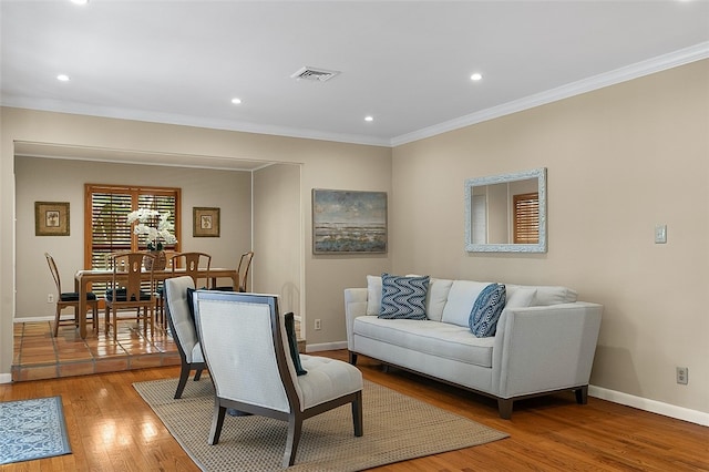 living room with crown molding and light hardwood / wood-style flooring