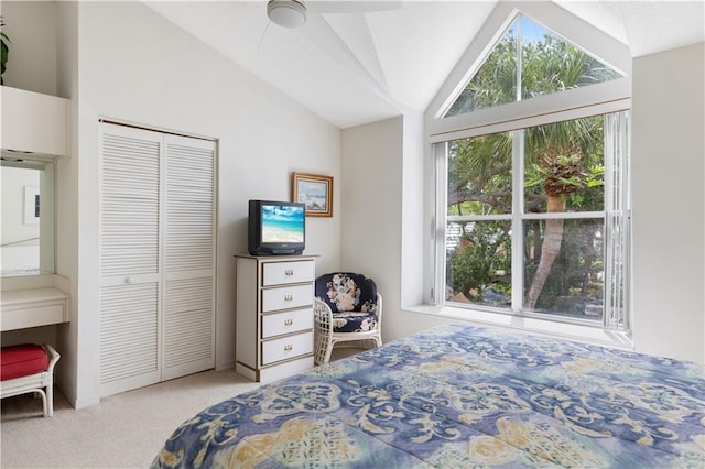 carpeted bedroom with a closet, vaulted ceiling, and ceiling fan