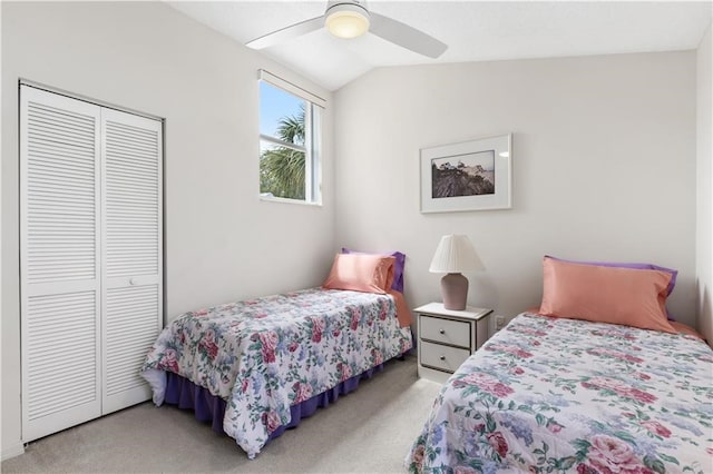 carpeted bedroom with ceiling fan, a closet, and vaulted ceiling