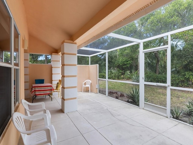 sunroom / solarium featuring a healthy amount of sunlight and vaulted ceiling