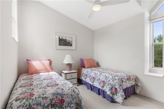 carpeted bedroom featuring ceiling fan, vaulted ceiling, and multiple windows