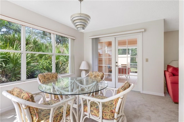 sunroom / solarium featuring french doors and a healthy amount of sunlight