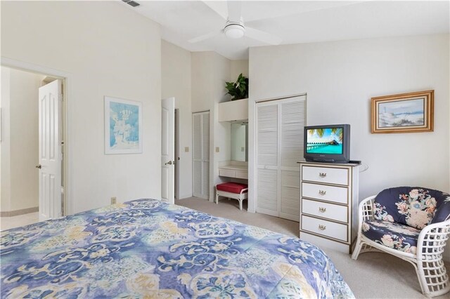 bedroom with ceiling fan, a towering ceiling, and light carpet