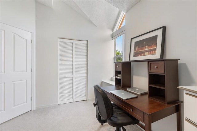 carpeted office with a textured ceiling and vaulted ceiling