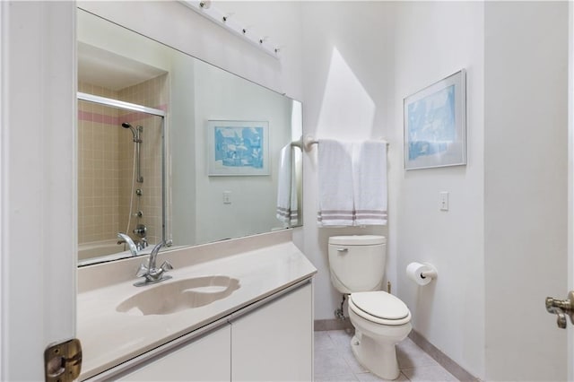 full bathroom with tile patterned flooring, vanity, tiled shower / bath combo, and toilet