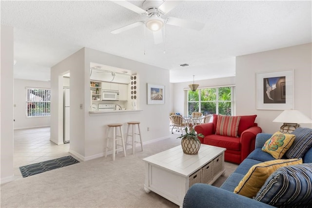 carpeted living room featuring a textured ceiling and ceiling fan