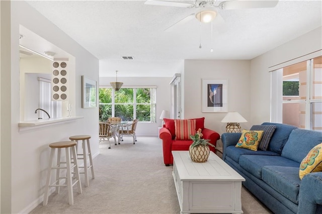 carpeted living room featuring ceiling fan