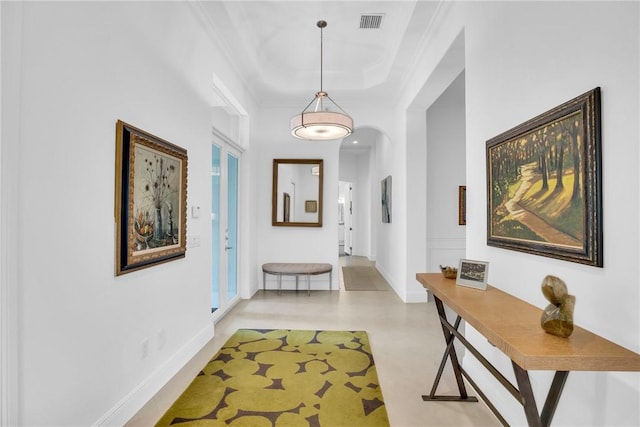 1242 River Reach Dr, Vero Beach, FL 32967 - hall featuring ornamental molding, arched walkways, a tray ceiling, and baseboards