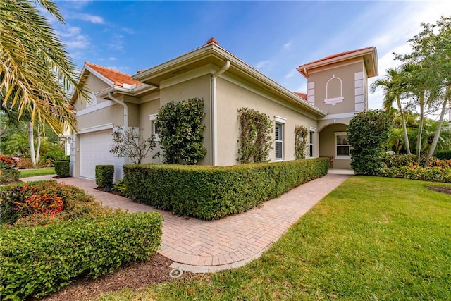 1242 River Reach Dr, Vero Beach, FL 32967 - view of front facade with stucco siding, a front lawn, and an attached garage
