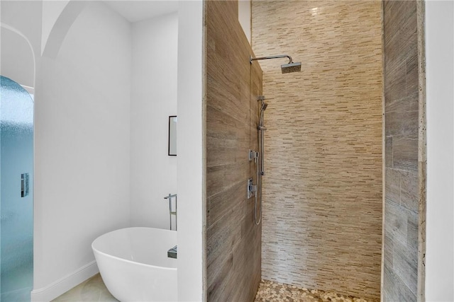 1242 River Reach Dr, Vero Beach, FL 32967 - bathroom featuring a stall shower, a freestanding tub, and tile patterned floors