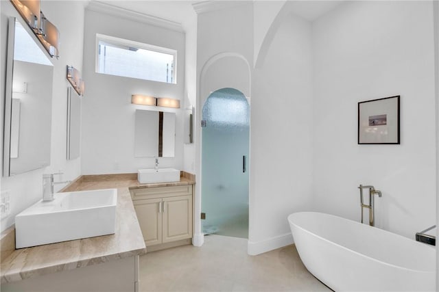 1242 River Reach Dr, Vero Beach, FL 32967 - full bath featuring double vanity, a freestanding bath, a stall shower, crown molding, and baseboards