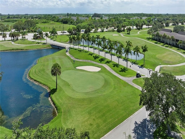 drone / aerial view with golf course view and a water view