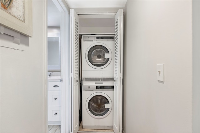 clothes washing area with stacked washer / drying machine and laundry area