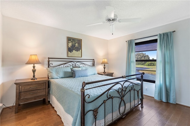 bedroom featuring a textured ceiling, ceiling fan, and wood finished floors