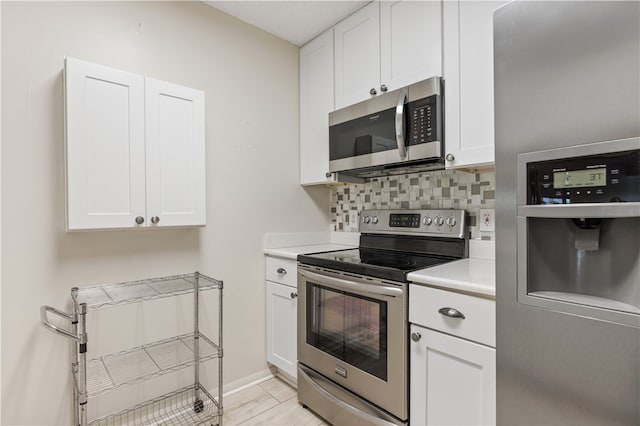 kitchen featuring white cabinets, decorative backsplash, and stainless steel appliances