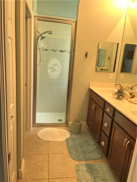 bathroom with tile patterned flooring, vanity, and a shower with shower door