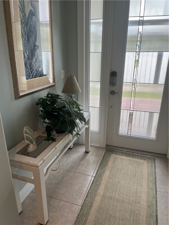 doorway to outside with light tile patterned floors