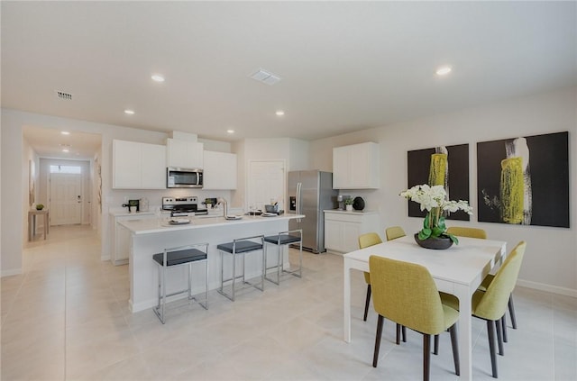 dining space featuring light tile patterned floors, baseboards, visible vents, and recessed lighting