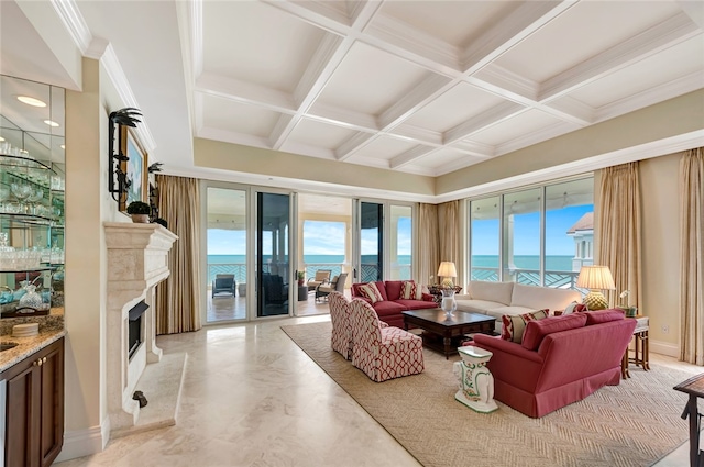 living room featuring a fireplace, plenty of natural light, a water view, and coffered ceiling