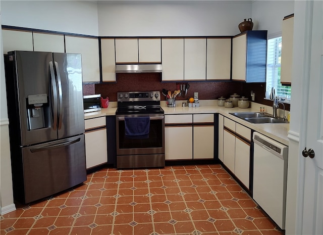 kitchen with tasteful backsplash, white cabinetry, sink, and appliances with stainless steel finishes