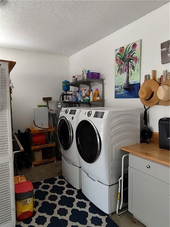 laundry area featuring washer and clothes dryer and a textured ceiling