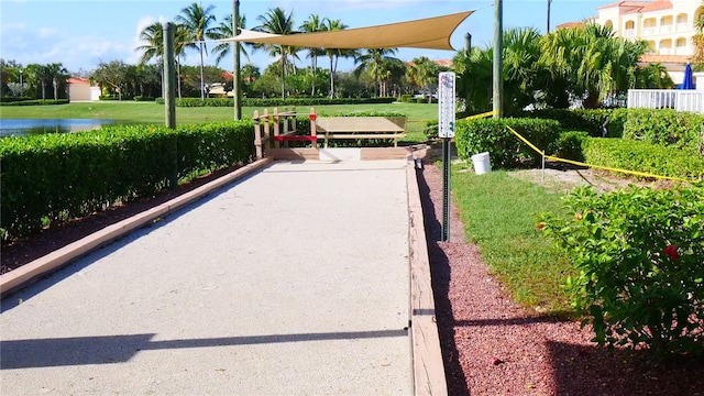 view of home's community with a water view and a yard