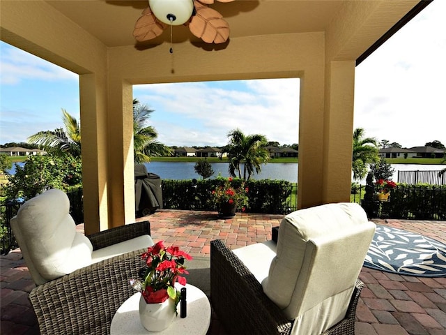 view of patio featuring ceiling fan and a water view