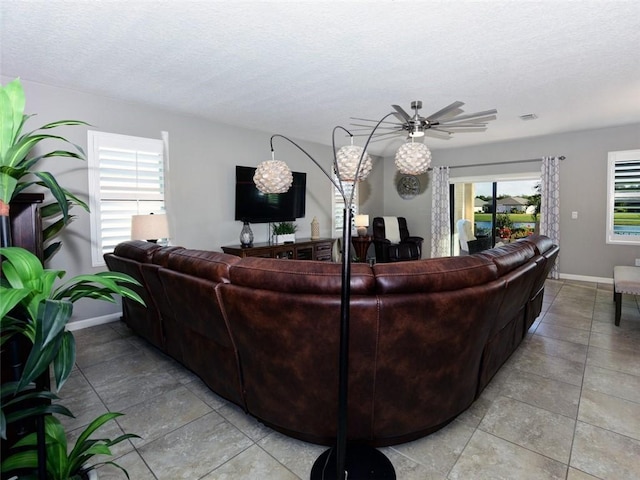 living room featuring a textured ceiling, a wealth of natural light, and ceiling fan