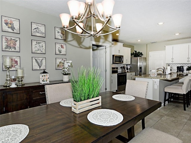 dining space with sink and an inviting chandelier