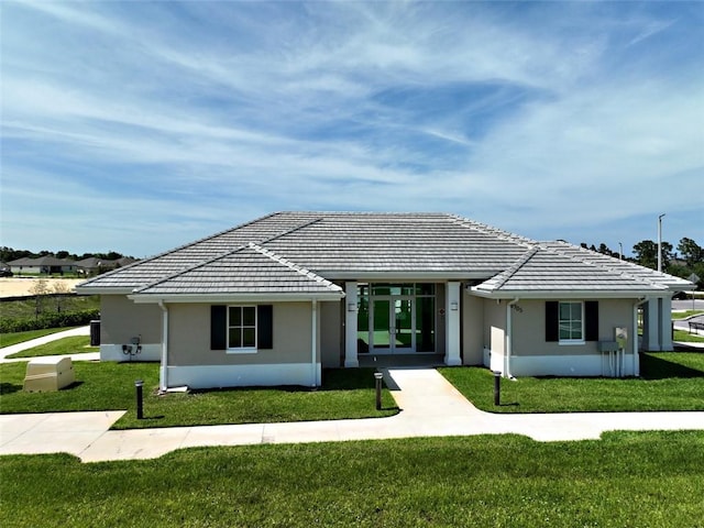 view of front of property with french doors and a front lawn