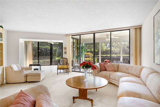 carpeted living room with ceiling fan and a textured ceiling