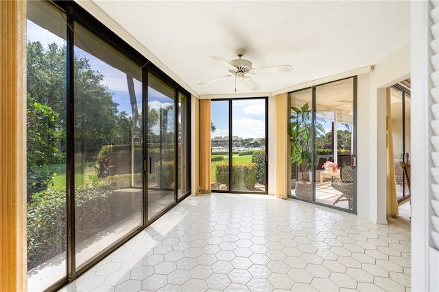 unfurnished sunroom with ceiling fan