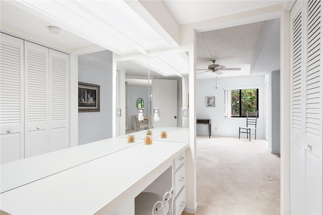 bathroom with ceiling fan and a textured ceiling