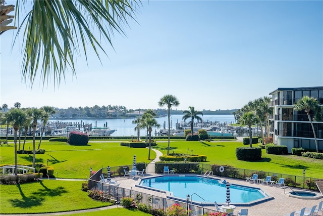 view of swimming pool featuring a yard and a water view