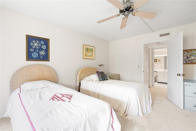 bedroom with ensuite bath, ceiling fan, light carpet, and a textured ceiling