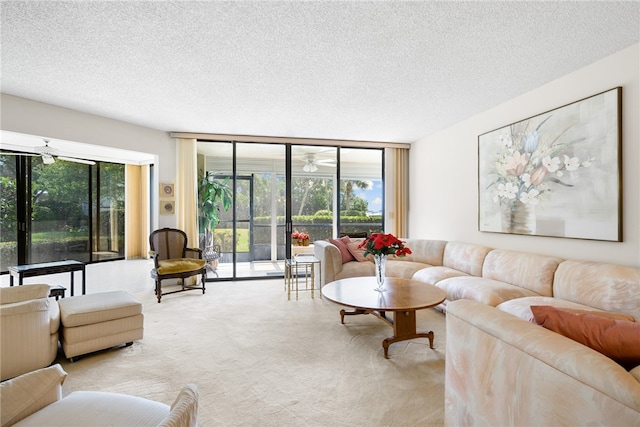 living room featuring light carpet, a textured ceiling, a wall of windows, and ceiling fan